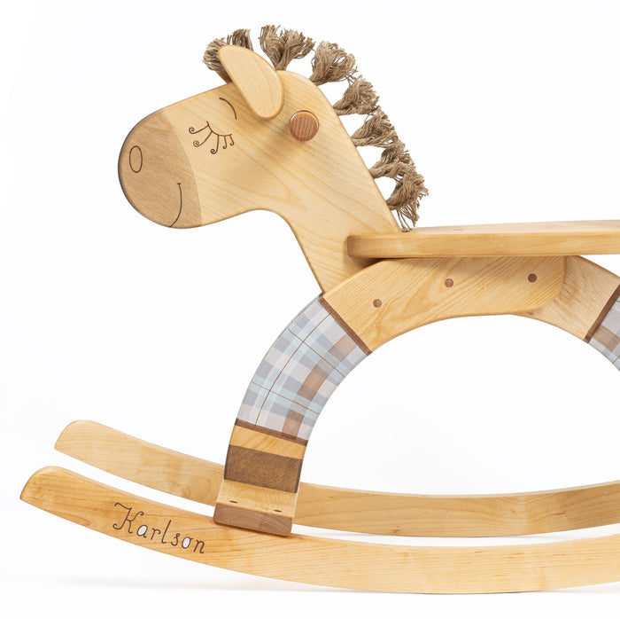 A wooden rocking horse with a blue plaid seat